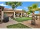Backyard showcasing covered patio, lush lawn, desert landscaping, and a tranquil ambiance at 4187 E Triple Crown Dr, San Tan Valley, AZ 85140