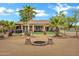 Expansive backyard with mature trees, a fire pit, and desert-style landscaping at 4187 E Triple Crown Dr, San Tan Valley, AZ 85140