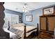 Comfortable bedroom with soft blue walls, natural light, and dark wood furniture at 4187 E Triple Crown Dr, San Tan Valley, AZ 85140