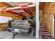Spacious garage featuring an automotive lift, wooden walls, storage cabinets, and access to a wooden staircase at 4187 E Triple Crown Dr, San Tan Valley, AZ 85140