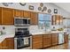 Kitchen with wood cabinets, stainless steel appliances, white countertops, and tile backsplash, plus a window view at 4187 E Triple Crown Dr, San Tan Valley, AZ 85140