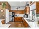 Bright kitchen featuring stainless steel appliances, wood cabinets, granite countertops, and neutral tile flooring at 4187 E Triple Crown Dr, San Tan Valley, AZ 85140