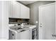 Laundry room featuring white cabinets, shelving, and modern front-loading washer and dryer at 4187 E Triple Crown Dr, San Tan Valley, AZ 85140