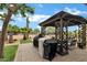 Outdoor entertainment area featuring a covered pergola with seating and two barbecue grills on a brick paved patio at 4187 E Triple Crown Dr, San Tan Valley, AZ 85140