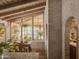Dining area with wooden table, chandelier, and views of the desert landscape and swimming pool at 4747 E Arroyo Verde Dr, Paradise Valley, AZ 85253
