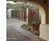 View of the long driveway with stone pavers, arched entryway, desert landscape, wooden gate and accent lighting at 4747 E Arroyo Verde Dr, Paradise Valley, AZ 85253