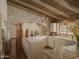 Bright kitchen with white cabinets, arched brick accent wall, tile countertops and wooden beamed ceiling at 4747 E Arroyo Verde Dr, Paradise Valley, AZ 85253