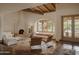 Open-concept living room with fireplace, seating area, and arched window featuring desert views at 4747 E Arroyo Verde Dr, Paradise Valley, AZ 85253