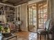 Inviting living room with terra cotta tile flooring, bookshelves, and French doors to outdoor space at 4747 E Arroyo Verde Dr, Paradise Valley, AZ 85253