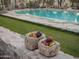 Sparkling pool with lush green lawn surrounded by playful bocce balls in stone bowls at 4747 E Arroyo Verde Dr, Paradise Valley, AZ 85253