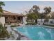 Beautiful pool area featuring a stone trim, lush greenery, and outdoor living space for entertaining at 4747 E Arroyo Verde Dr, Paradise Valley, AZ 85253