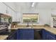 This kitchen features granite countertops, blue and white cabinetry, and stainless steel appliances at 4854 E Evergreen St, Mesa, AZ 85205