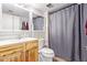 Cozy bathroom featuring a wood vanity and a shower with daisy shower curtain at 5923 W Mauna Loa Ln, Glendale, AZ 85306