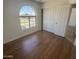 This bright bedroom features wood floors, a large arched window and a closet with sliding doors at 6416 N 78Th Ln, Glendale, AZ 85303