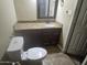 Bathroom with a white toilet, single sink, granite countertop, and dark brown cabinets at 6530 W Turney Ave, Phoenix, AZ 85033