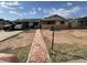 Modest home exterior with solar panels, brick pathway, and a covered carport at 6530 W Turney Ave, Phoenix, AZ 85033