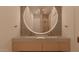 Modern bathroom featuring a frameless glass shower, and double sink vanity with large, lighted round mirror at 6649 E Ocotillo Rd, Paradise Valley, AZ 85253