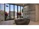 Modern bathroom showcasing a freestanding tub and double showers, and a view of the serene outdoors at 6649 E Ocotillo Rd, Paradise Valley, AZ 85253