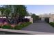Gated driveway leading to a modern home, featuring lush landscaping and mature trees at 6649 E Ocotillo Rd, Paradise Valley, AZ 85253