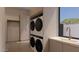 Modern laundry room featuring stacked washer and dryer units and a countertop at 6649 E Ocotillo Rd, Paradise Valley, AZ 85253