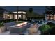 Stylish outdoor lounge area with a modern fire pit, comfortable seating, and views of the pool and home at 6649 E Ocotillo Rd, Paradise Valley, AZ 85253