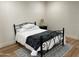 Simple bedroom with black metal bed frame, plush bedding, and decorative rug on laminate flooring at 703 E Corte Oro --, Phoenix, AZ 85020