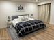 Well-lit bedroom with a ceiling fan, light wood flooring, decorative rug, and comfortable, furnished bed at 703 E Corte Oro --, Phoenix, AZ 85020