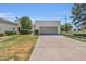 Single-story home with a two-car garage, mature trees, a desert landscaped front yard, and a long driveway at 703 E Corte Oro --, Phoenix, AZ 85020
