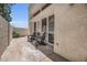 Cozy outdoor patio with stucco wall, two wooden chairs and lush green landscaping at 703 E Corte Oro --, Phoenix, AZ 85020