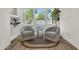 Bright sitting area with comfortable armchairs, accent table, indoor plants, and large windows at 703 E Corte Oro --, Phoenix, AZ 85020