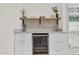 Stylish wet bar features a built-in wine cooler, quartz countertop, floating wood shelf, and decorative backsplash at 703 E Corte Oro --, Phoenix, AZ 85020