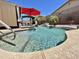 Sparkling backyard pool featuring rock accents, palm trees, and a shady pergola nearby at 723 S Weaver Dr, Apache Junction, AZ 85120