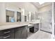 Bathroom with dual sinks, modern cabinets, skylight, and a glass-enclosed shower with gray tile at 7272 E Gainey Ranch Rd # 117, Scottsdale, AZ 85258