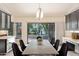 Bright dining room with modern chandelier and sliding door to view of fountain and landscaping at 7272 E Gainey Ranch Rd # 117, Scottsdale, AZ 85258