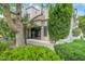 A charming home featuring a stucco exterior, mature trees, and lush landscaping, creating a welcoming atmosphere at 7272 E Gainey Ranch Rd # 117, Scottsdale, AZ 85258