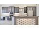 This kitchen features dark cabinets, stainless steel appliances, and a tile backsplash for a modern design at 7272 E Gainey Ranch Rd # 117, Scottsdale, AZ 85258