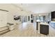 Bright, airy living room with wood-look floors and an open layout leading to the kitchen and outdoor space at 7272 E Gainey Ranch Rd # 117, Scottsdale, AZ 85258