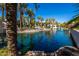 Scenic community pond with a fountain, palm trees, and lush landscaping, providing a tranquil and picturesque setting at 7272 E Gainey Ranch Rd # 117, Scottsdale, AZ 85258