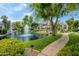 Scenic view of a community pond with a fountain, lush greenery, and a walking path, creating a relaxing environment at 7272 E Gainey Ranch Rd # 117, Scottsdale, AZ 85258