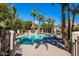 A luxurious community pool surrounded by palm trees, lounge chairs, and manicured landscaping, perfect for relaxation at 7272 E Gainey Ranch Rd # 117, Scottsdale, AZ 85258