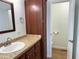 Bathroom boasts wood cabinetry, a modern basin sink, granite countertops, and a framed mirror at 7300 N 51St Ave # G102, Glendale, AZ 85301
