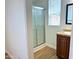 Bathroom features a glass enclosed shower and modern vanity with framed mirror and wood-style floors at 7300 N 51St Ave # G102, Glendale, AZ 85301