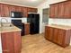 Updated kitchen features wood cabinets, granite counters, stainless steel sink and black appliances at 7300 N 51St Ave # G102, Glendale, AZ 85301