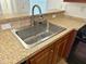 Stainless steel kitchen sink featuring a modern faucet and a tan countertop at 7300 N 51St Ave # G102, Glendale, AZ 85301