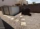 Backyard with a storage shed and rock landscaping with walkway stepping stones at 8006 W Gibson Ln, Phoenix, AZ 85043