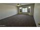Spacious bedroom featuring plush carpet, a ceiling fan, and a window overlooking the pool at 8006 W Gibson Ln, Phoenix, AZ 85043