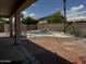Back yard view of the fenced in pool area with palm trees and lounge chair at 8006 W Gibson Ln, Phoenix, AZ 85043