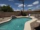 Backyard pool featuring a rock waterfall and a well-kept patio with lounge chair at 8006 W Gibson Ln, Phoenix, AZ 85043