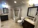 Spacious bathroom featuring dual vanities, a bathtub with shower, and neutral tiling at 860 N Mcqueen Rd # 1058, Chandler, AZ 85225