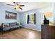 Relaxing bedroom featuring a futon couch, ceiling fan, laminate wood floors, and ample natural light at 860 N Mcqueen Rd # 1058, Chandler, AZ 85225